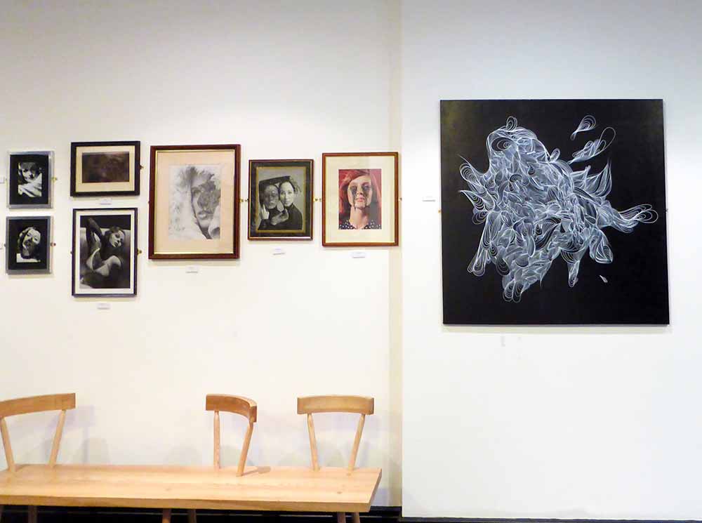 Selection of artworks by KEF! for his exhibition at Genesis Cinema featuring both framed artworks of old photographs painted on by him and also a large abstract artwork of his painted in white on a black canvas